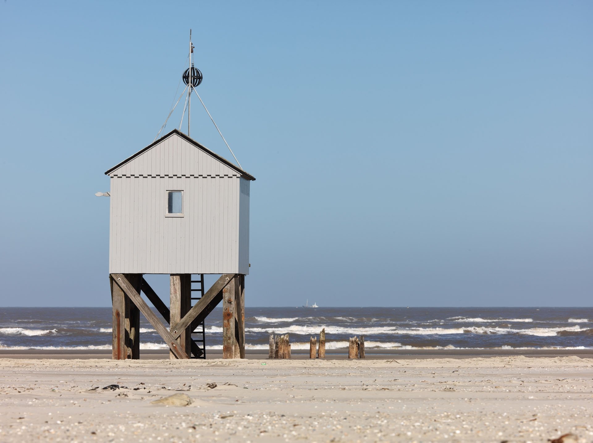 White beach hut raised on wooden stilts