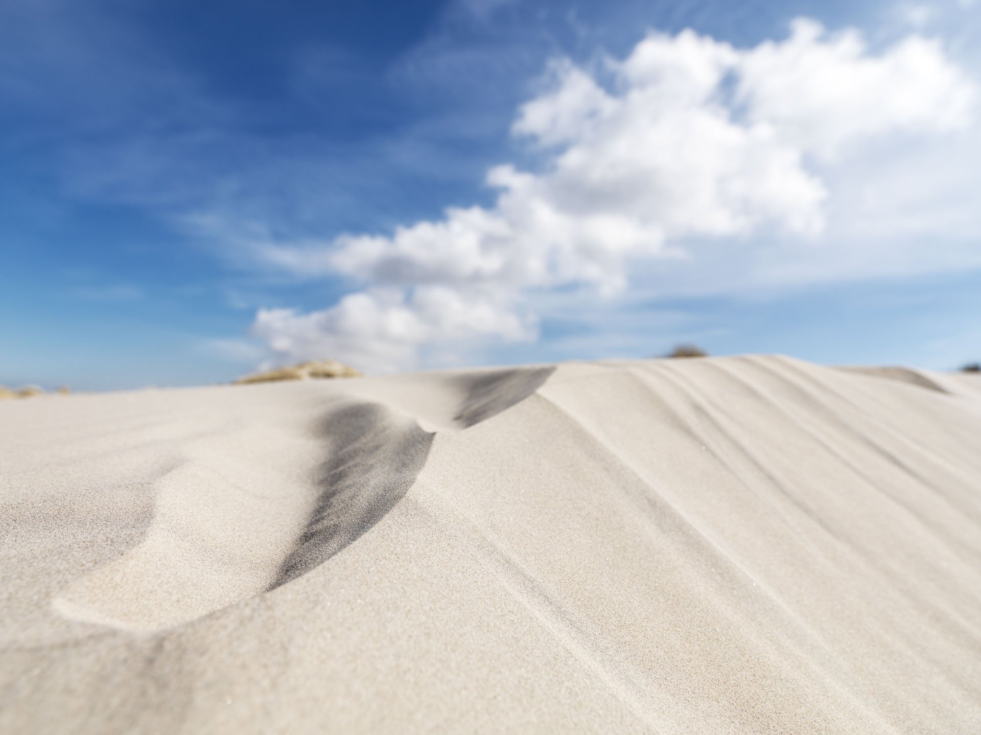 Wind-shaped sand ridges beneath a cloudy sky
