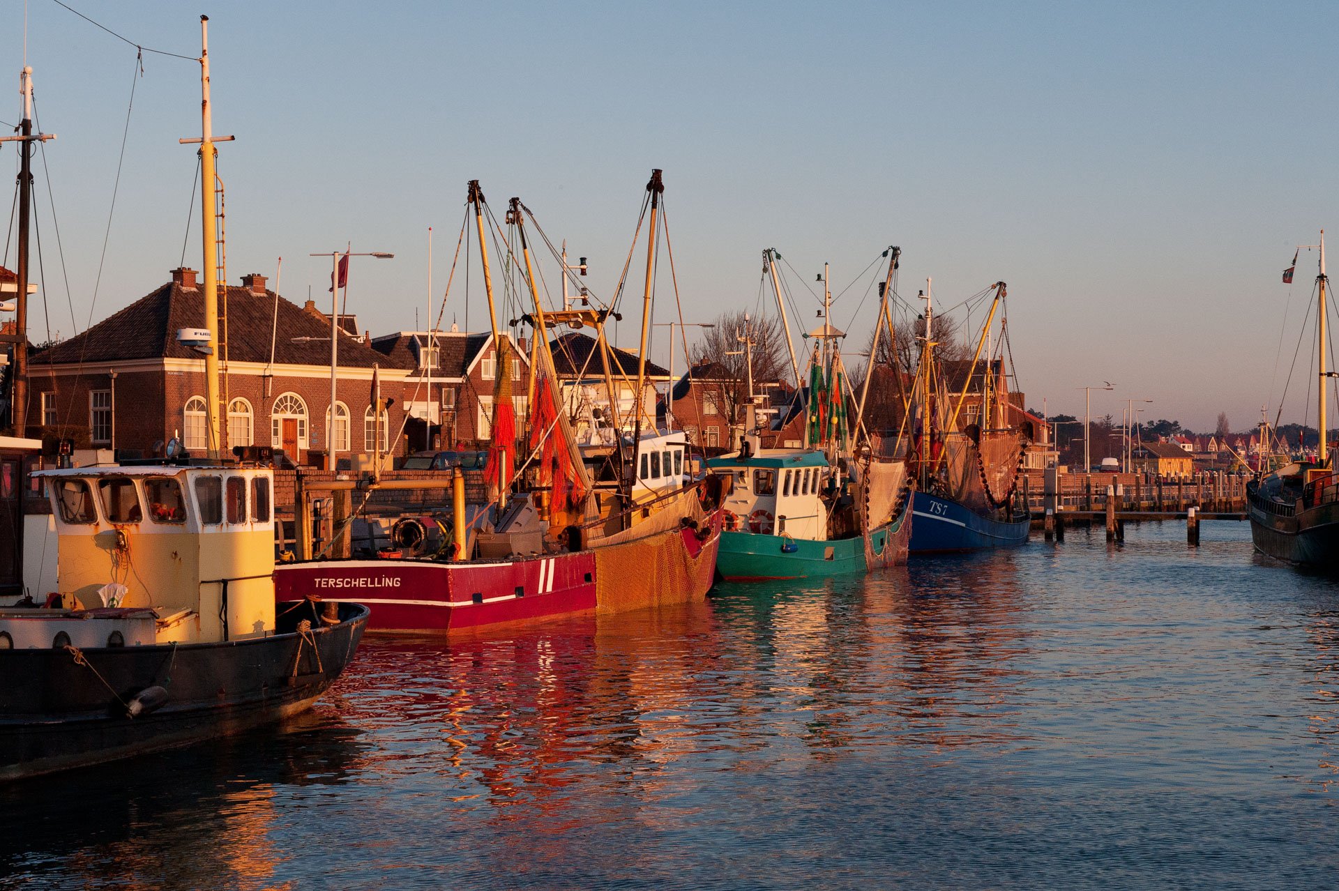 Fishing boats moored in a harbour in warm evening light