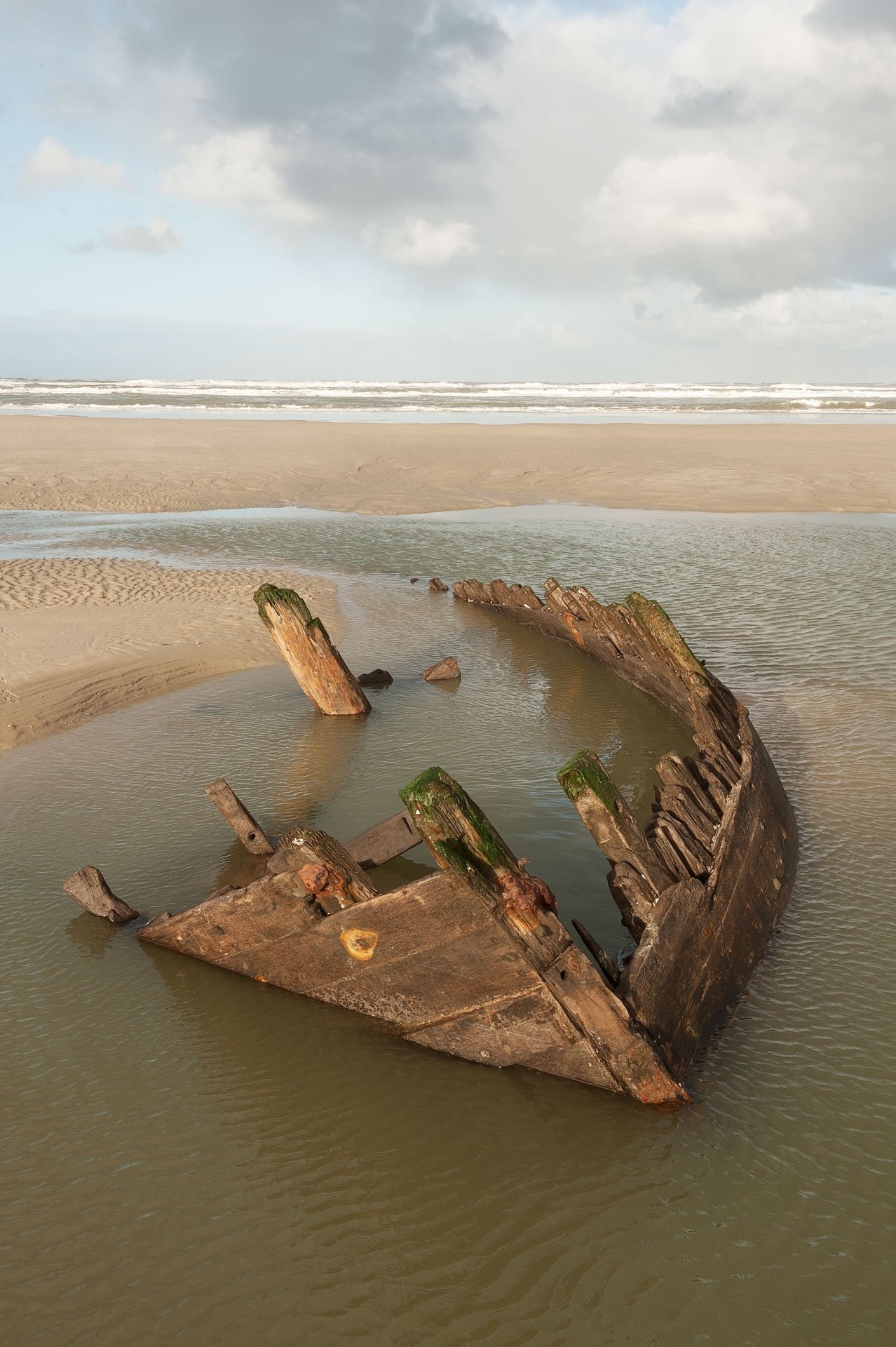 Rusted boat wreck on a sandy shore