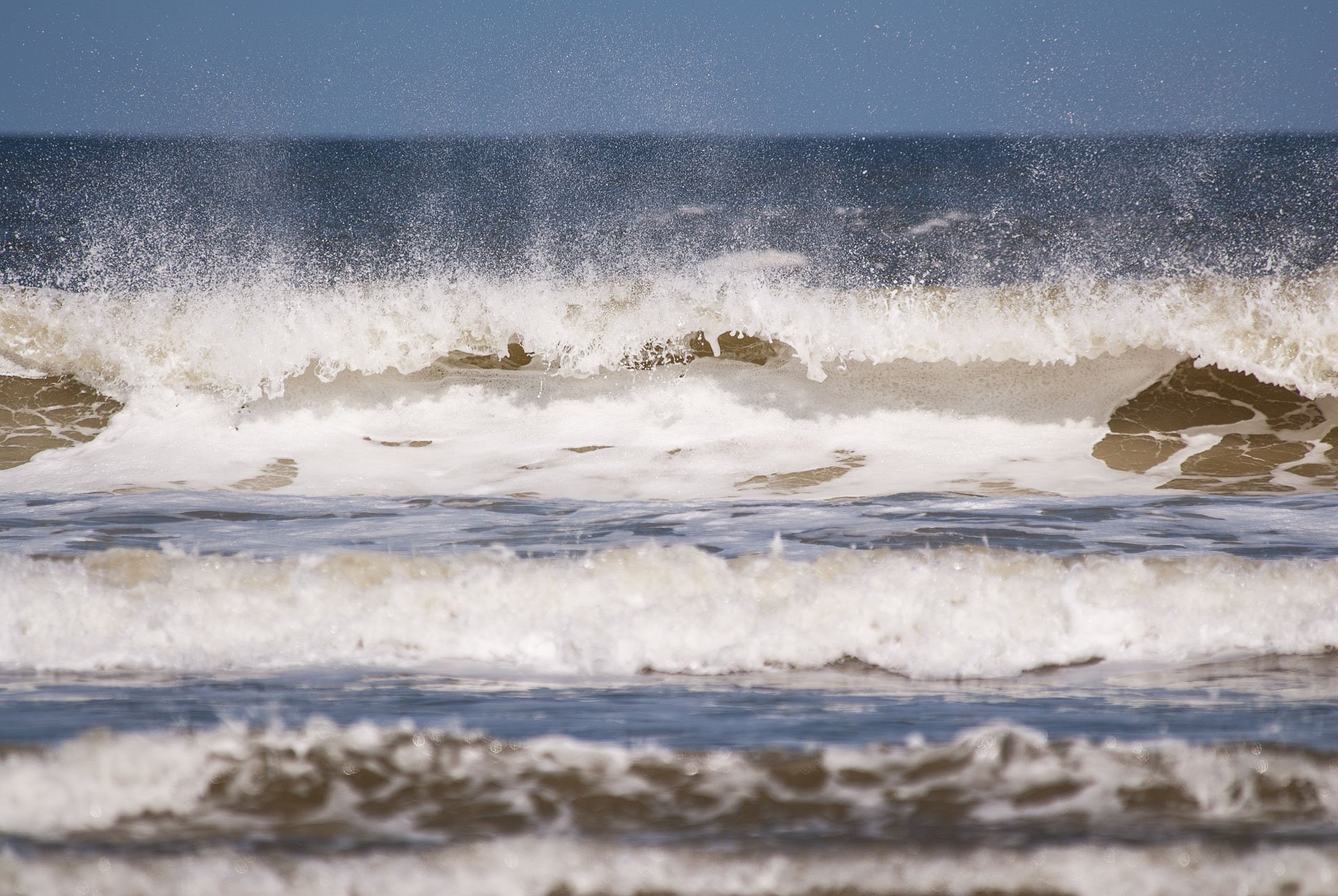 Breaking waves with wind-blown spray