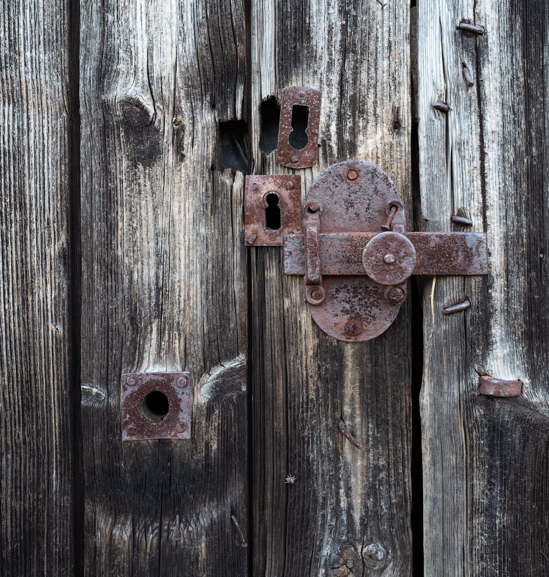 Rusty metal latch on weathered wooden doors